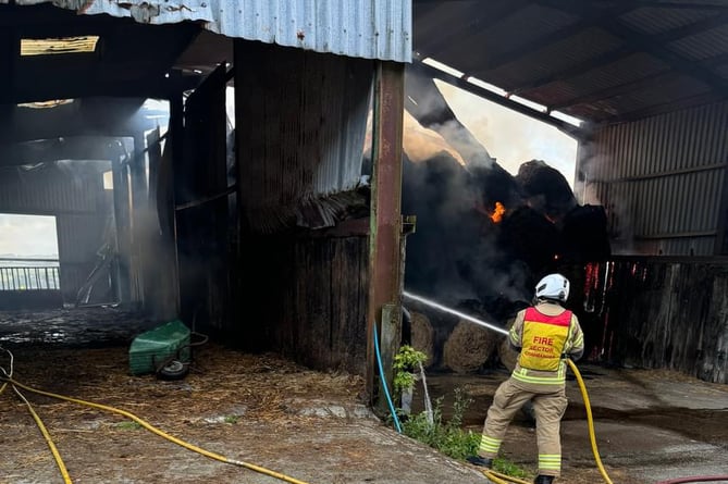 Tavistock firefighters helping damp down a barn fire at Lawhitton.