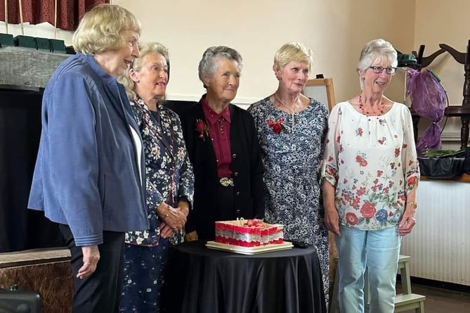 Long-standing members of Sampford Courtenay Flower Club cut their 40th birthday cake